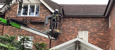 Super Clean South's operative in a cherry picker cleaning house gutters